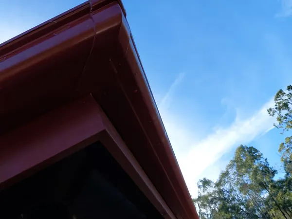 Manor red COLORBOND gutter and fascia against a clear blue sky on a rural property