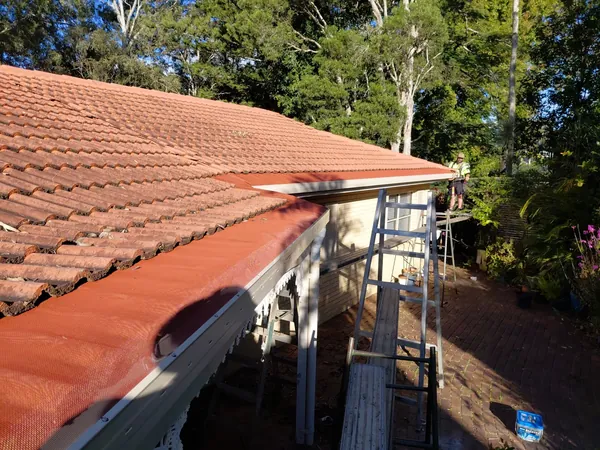 Fire-rated gutter guard mesh fitted along the edge of a terracotta tiled roof