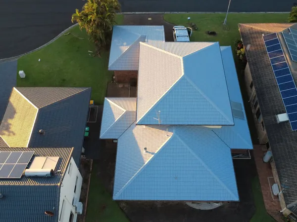 Aerial view of a restored tiled roof and guttering on a Lismore home at golden hour