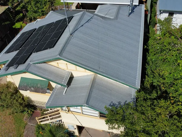 Grey corrugated COLORBOND roof with solar panels in a bushland setting