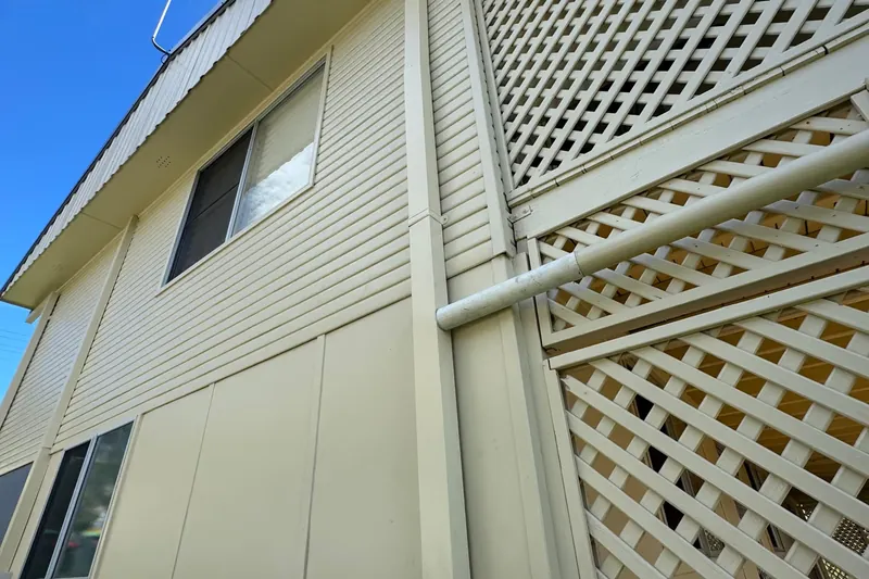 New cream metal fascia, gutter and rectangular downpipe on a two storey home